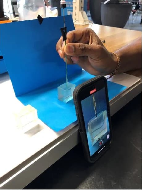 Project photograph of the first handheld pull setup with a Newton meter above a shallow gelatin specimen.